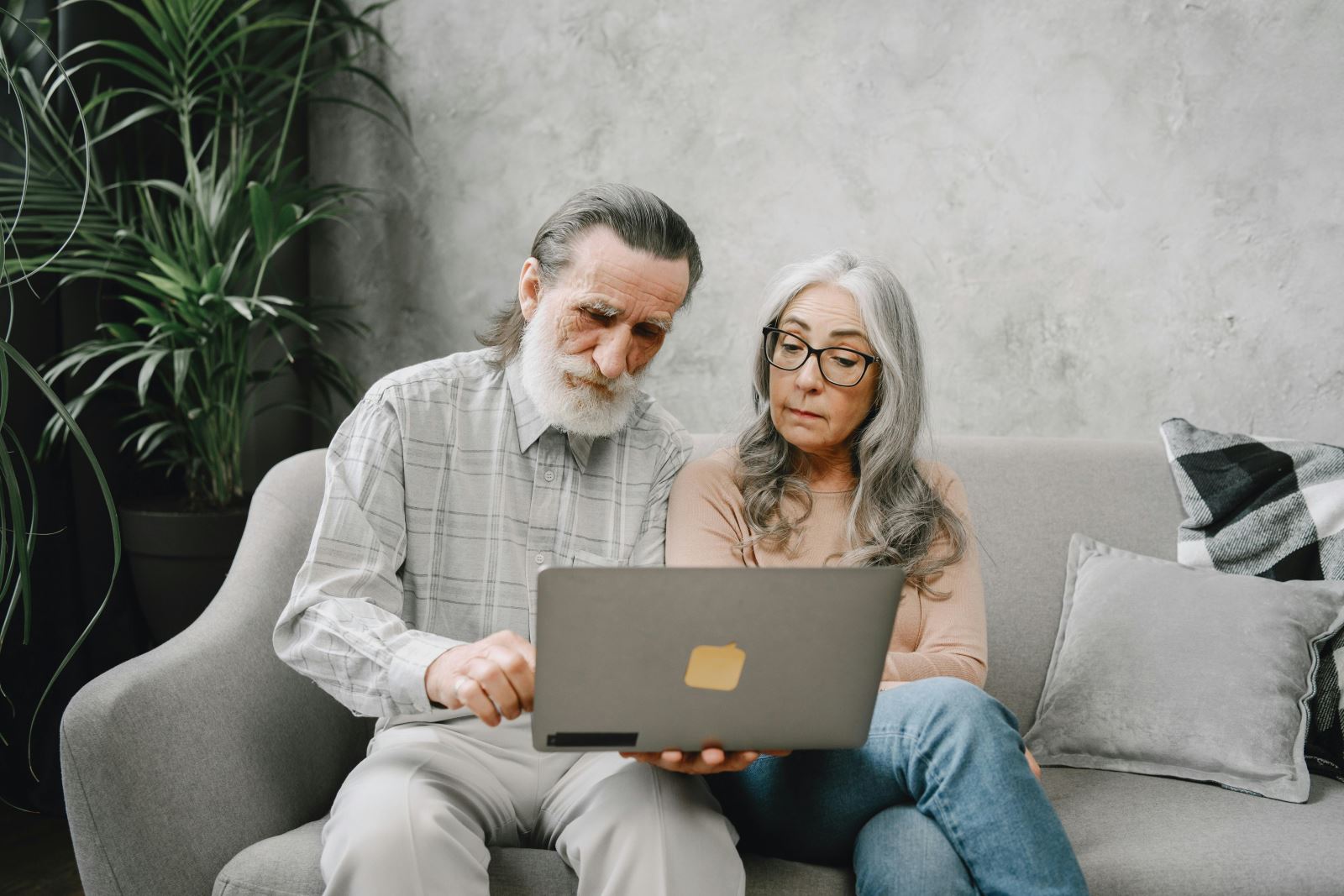 Elderly couple using laptop in their living room