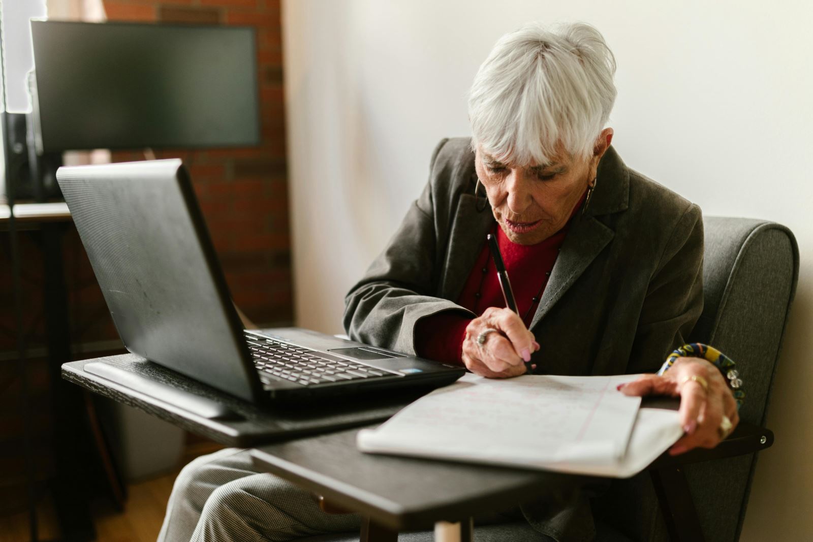 Elderly lady struggling with computer tasks